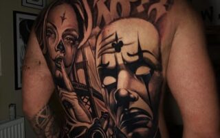 Großes Black & Grey Rücken-Tattoo mit Maske und Frauengesicht Großes Black & Grey Rücken-Tattoo mit Maske und Frauengesicht – Iron Ink Gevelsberg